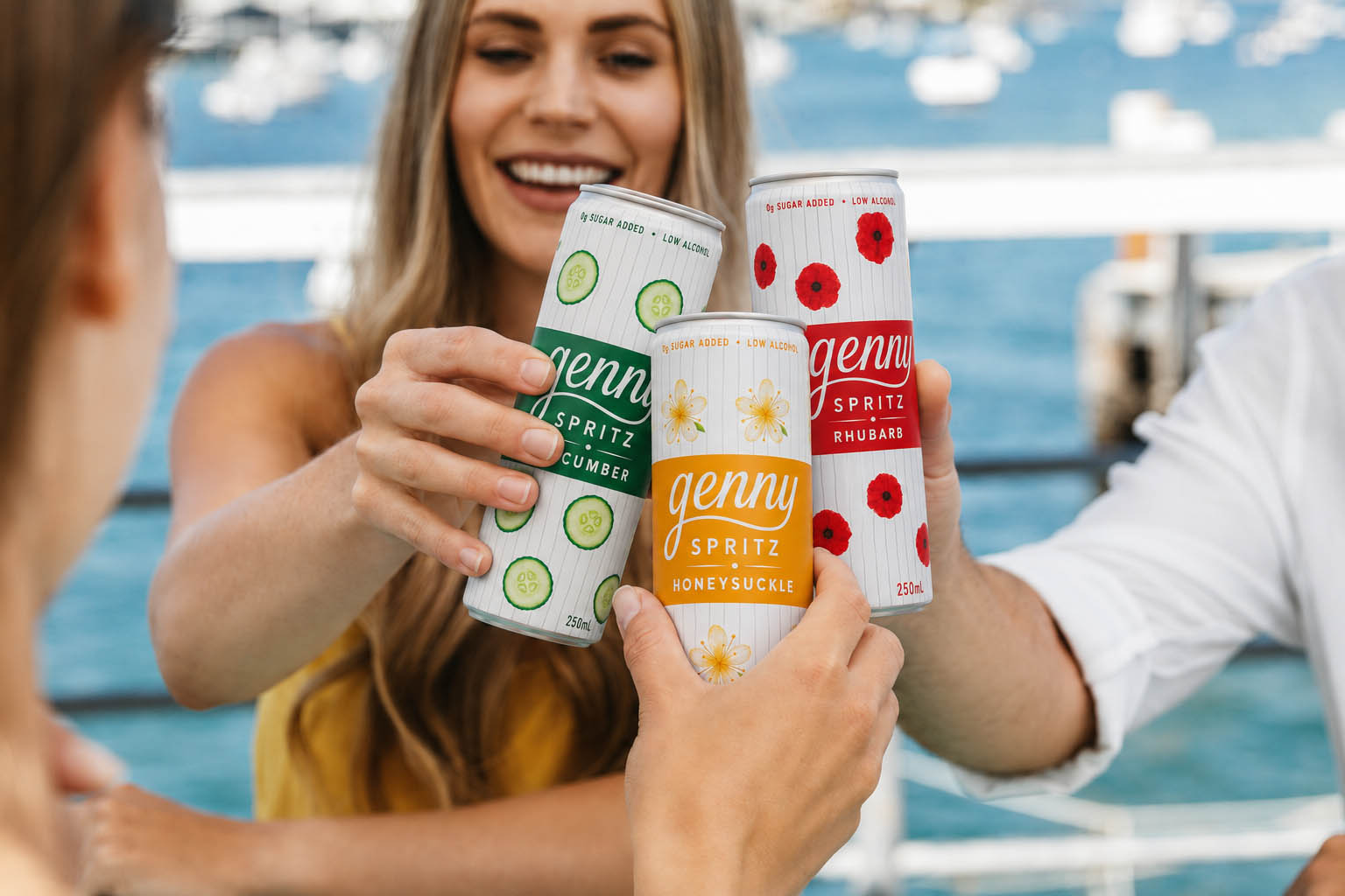 Friends toasting cans of genny spritz on a boat by the marina